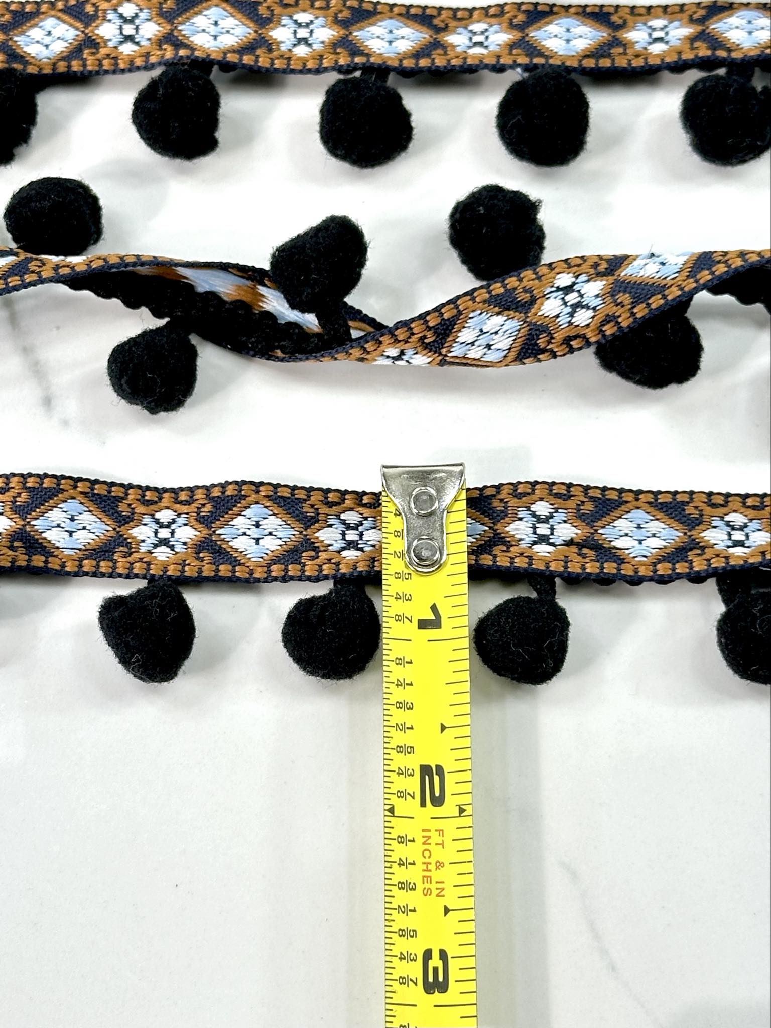 (TRIM) NAVY AND BLUE AZTEC PATTERN WITH BLACK POM POM BALL