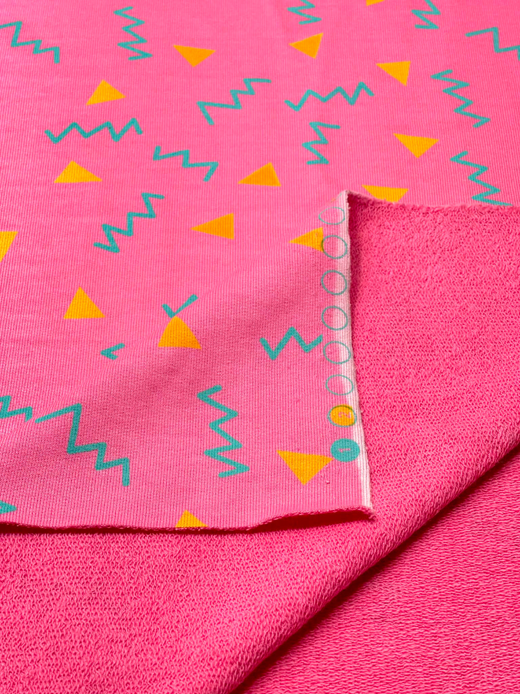 (HEAVY FRENCH TERRY) ORANGE TRIANGLES AND TURQUOISE SQUIGGLY ON PINK (1)