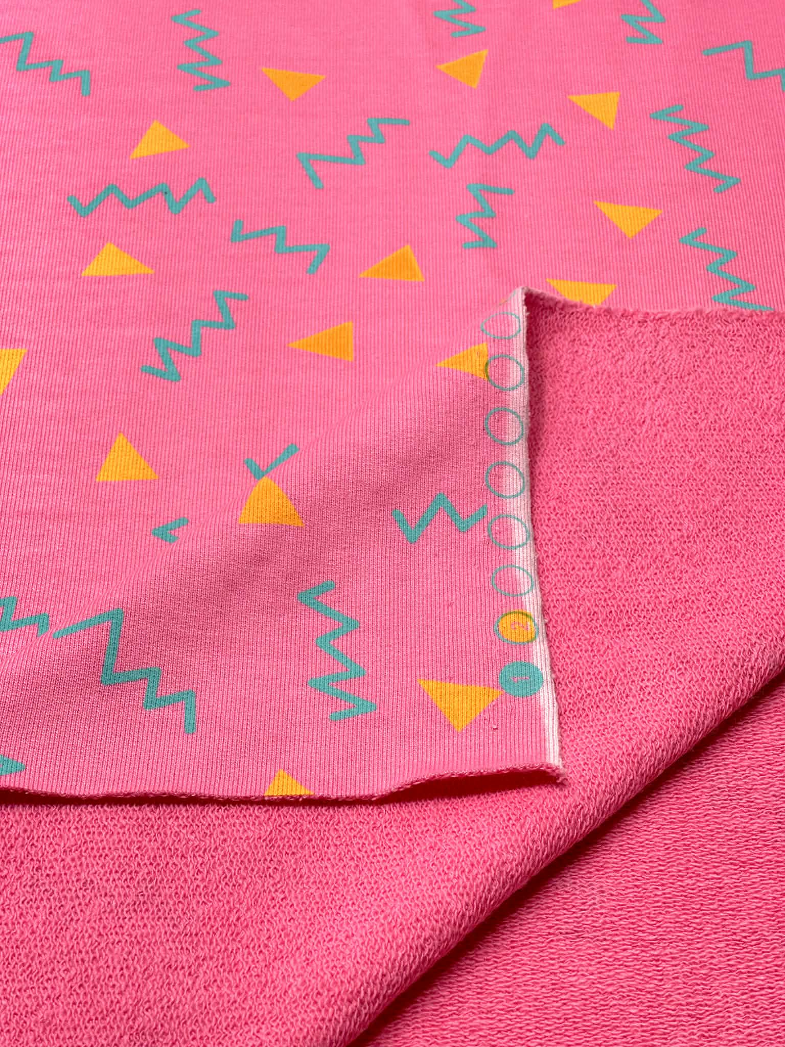 (HEAVY FRENCH TERRY) ORANGE TRIANGLES AND TURQUOISE SQUIGGLY ON PINK (1)