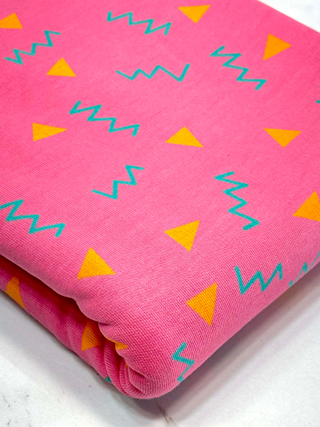 (HEAVY FRENCH TERRY) ORANGE TRIANGLES AND TURQUOISE SQUIGGLY ON PINK (1)