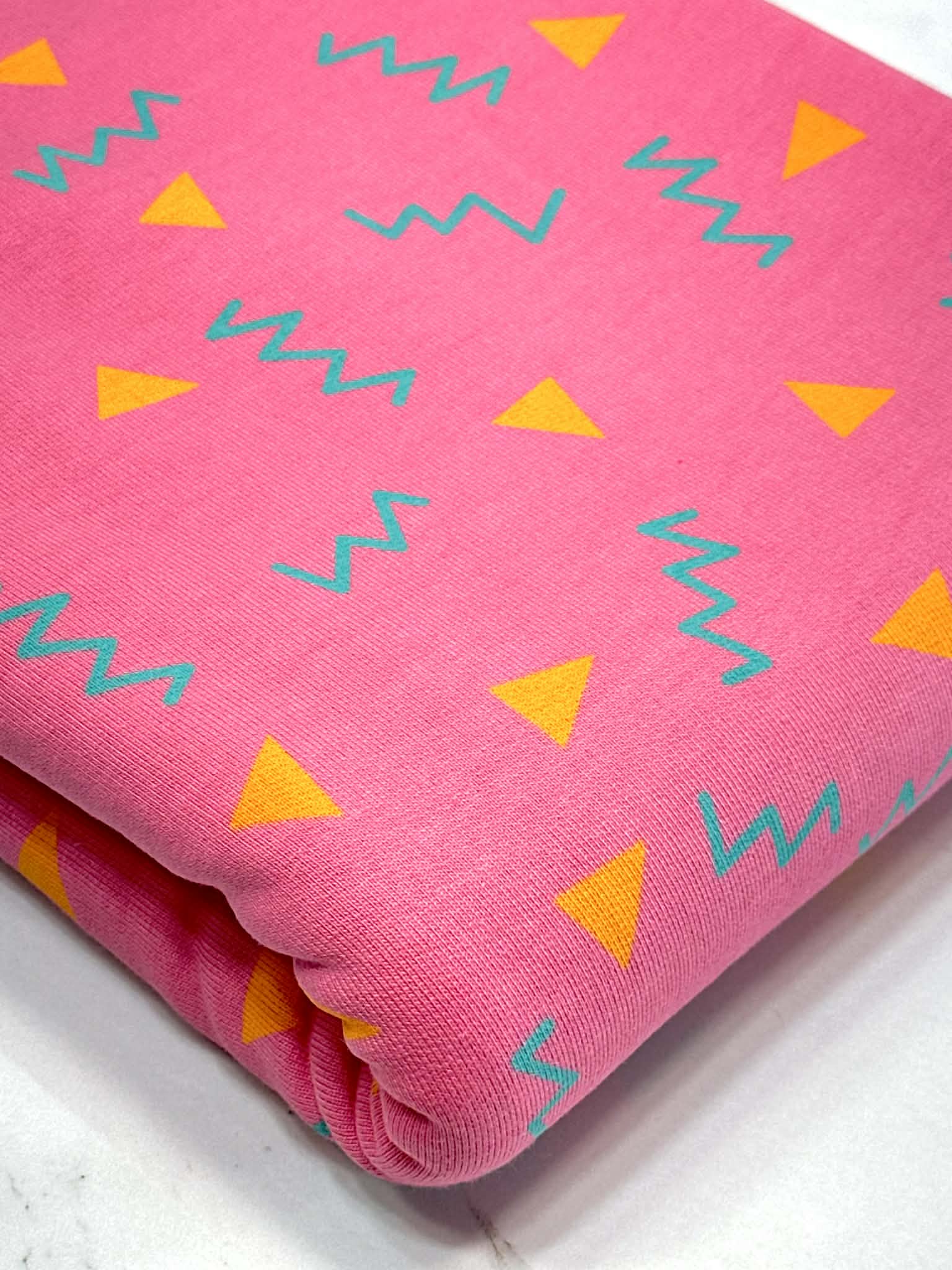 (HEAVY FRENCH TERRY) ORANGE TRIANGLES AND TURQUOISE SQUIGGLY ON PINK (1)